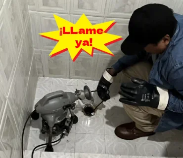 Profecional introduciendo cable en una coladera de regadera tapada por exceso de cabello, grasas y residuos